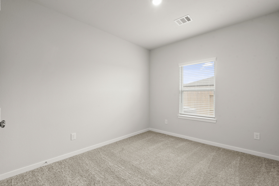 A room with a window and a carpet.