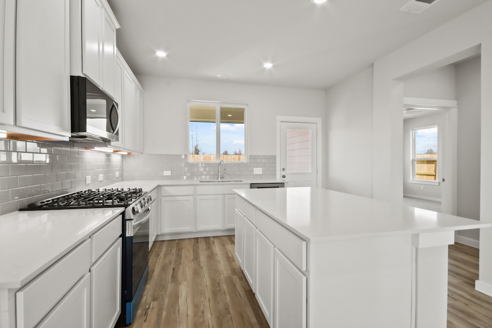 A kitchen with white cabinets.
