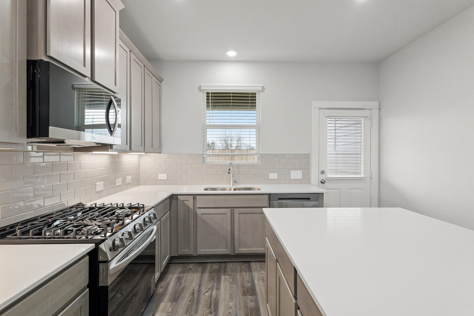 A kitchen with white cabinets.