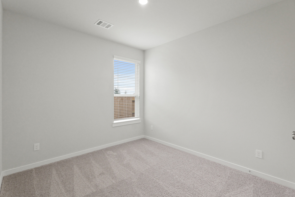 A room with a window and a carpet.