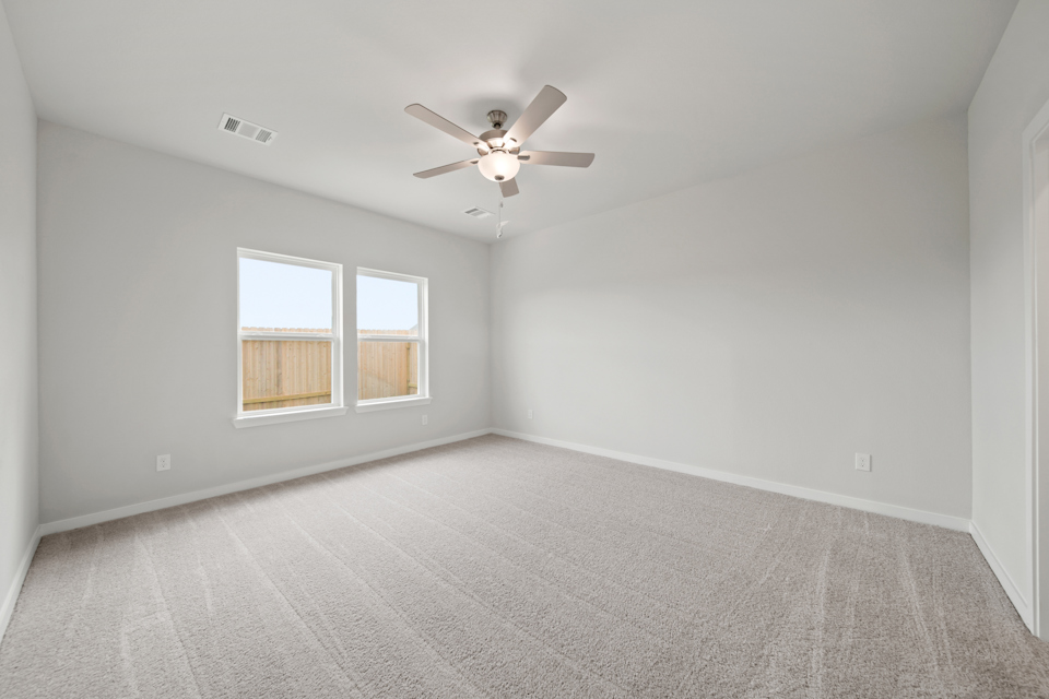 A room with a ceiling fan and a window.