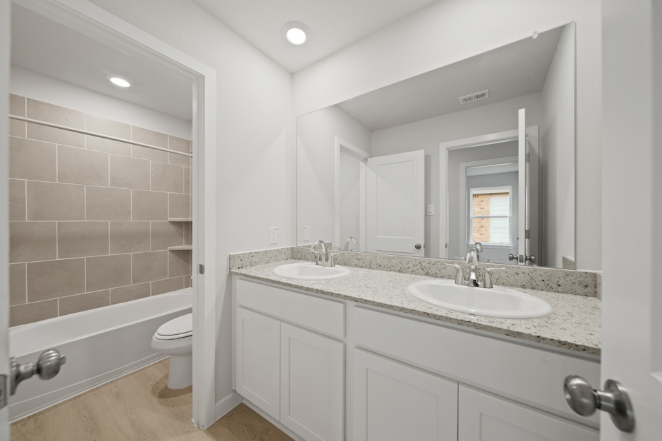 A bathroom with a large mirror.