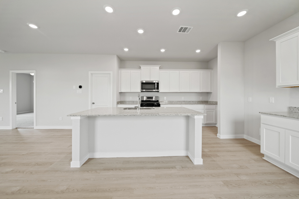 A kitchen with white cabinets.