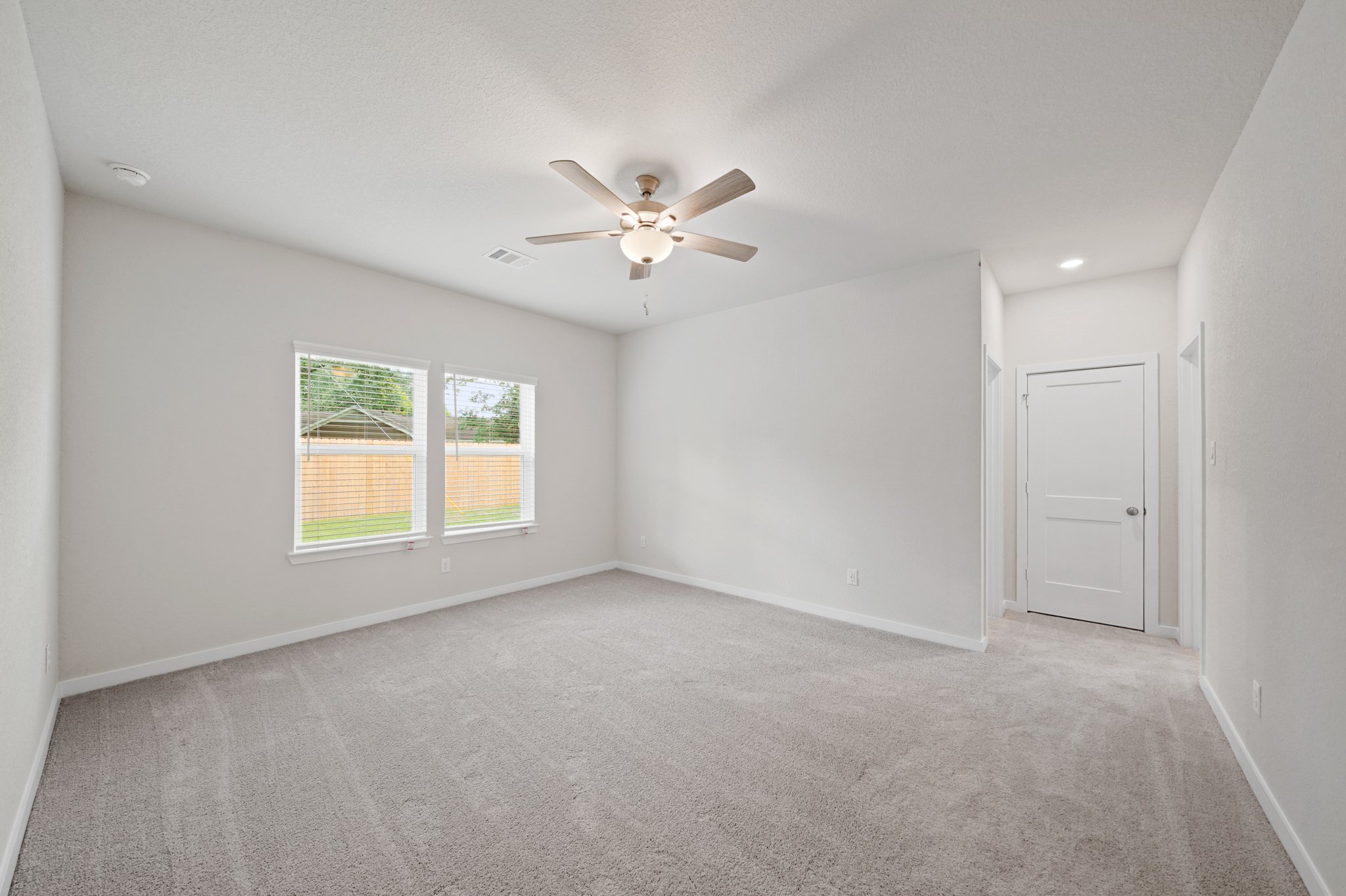 A room with a ceiling fan and a window.