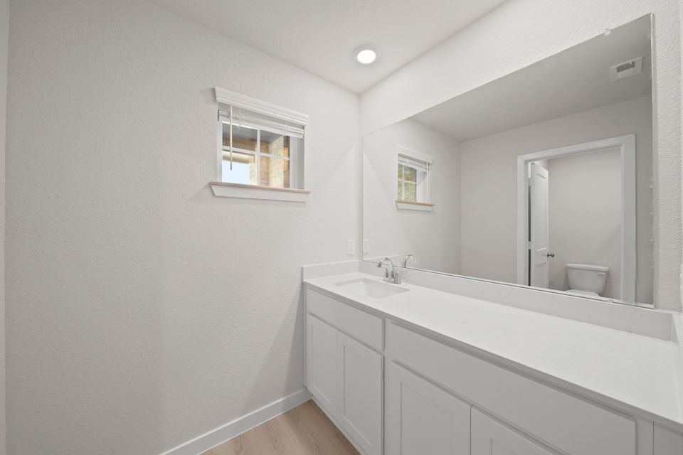 A bathroom with a large mirror.