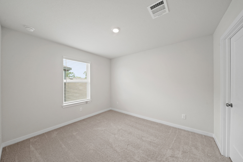 A room with a carpet and a window.