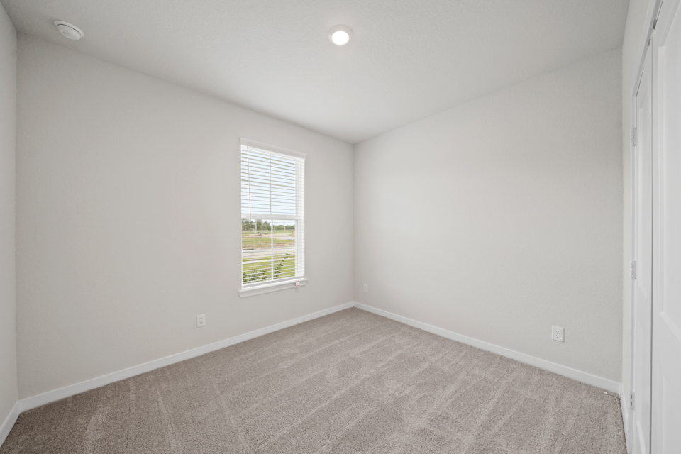 A room with a window and a carpet.