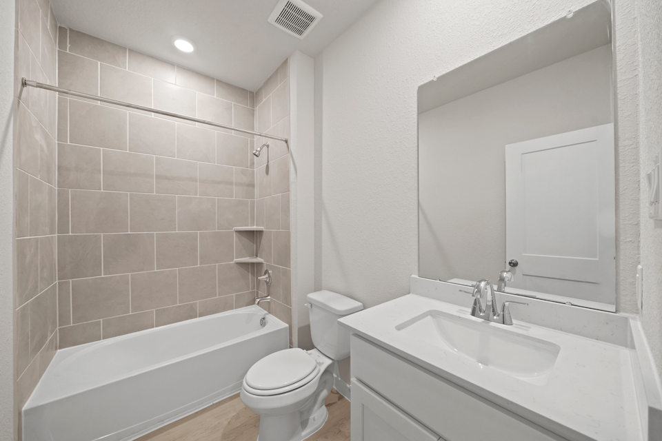 A bathroom with a tub sink and toilet.