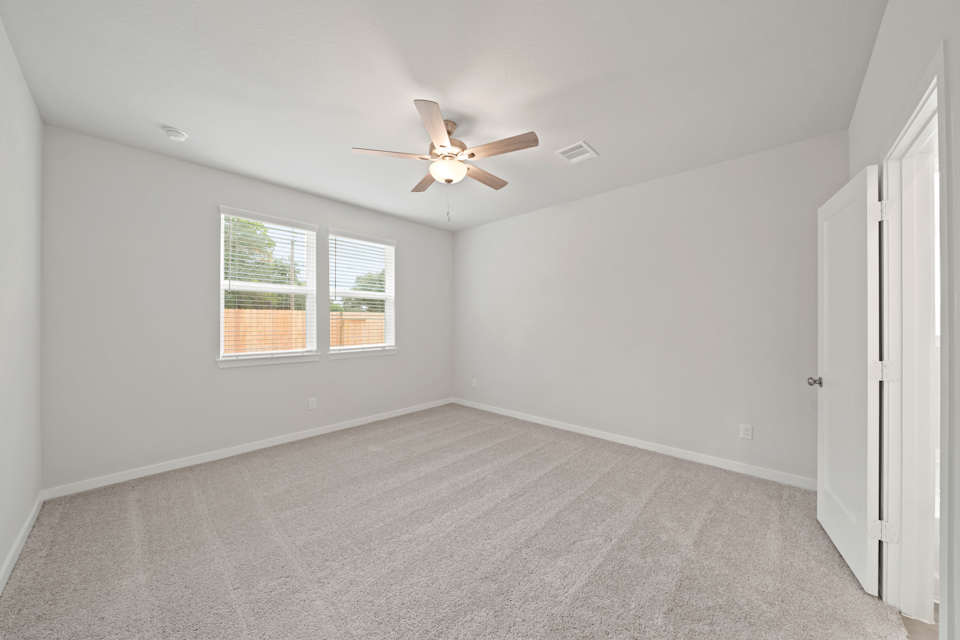 A room with a ceiling fan and a window.