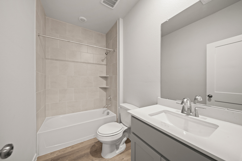 A bathroom with a tub sink and toilet.
