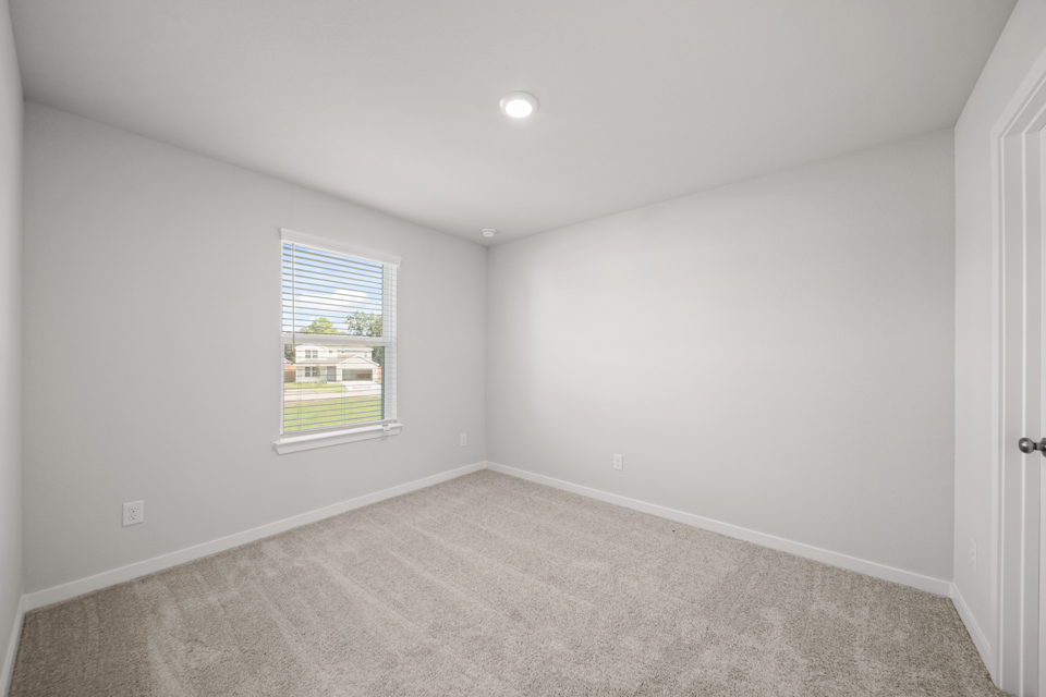 A room with a window and carpet.