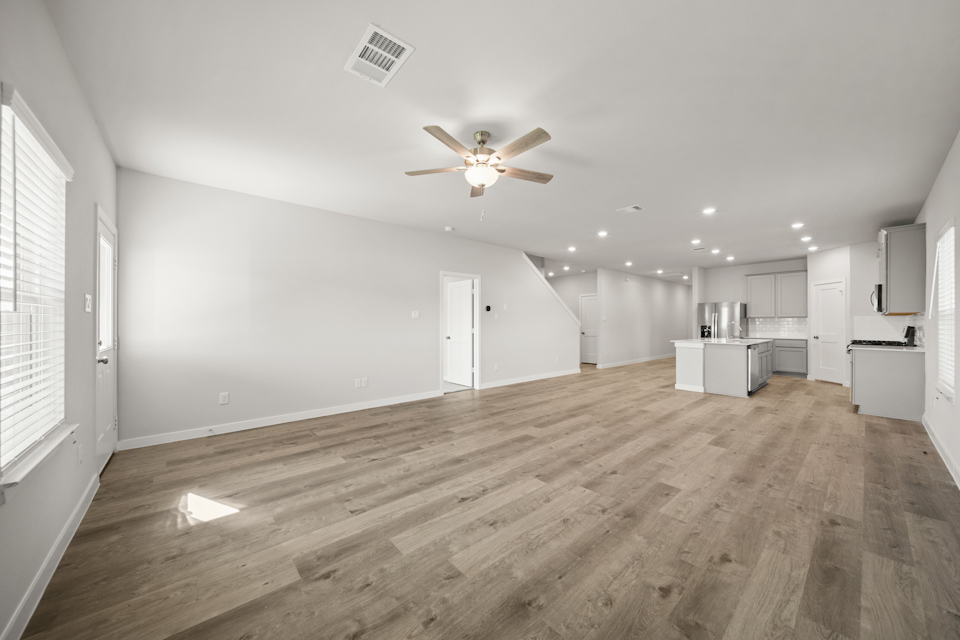 A room with a wood floor and a ceiling fan.