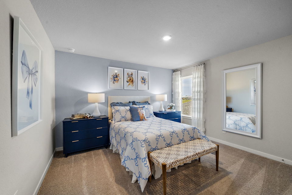 A bedroom with a bed and a bench.