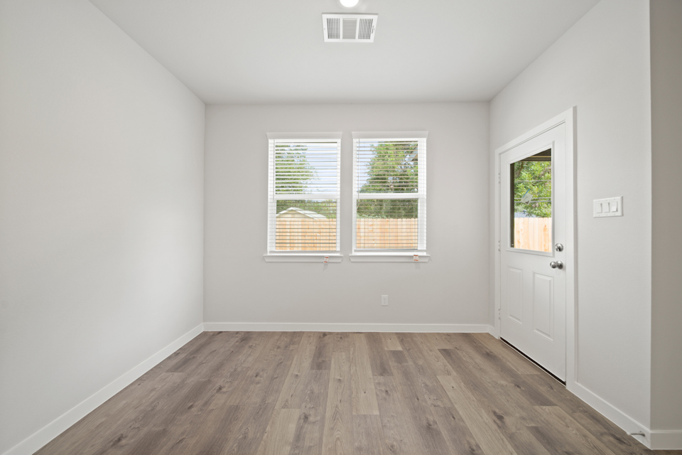 A room with a wood floor and windows.