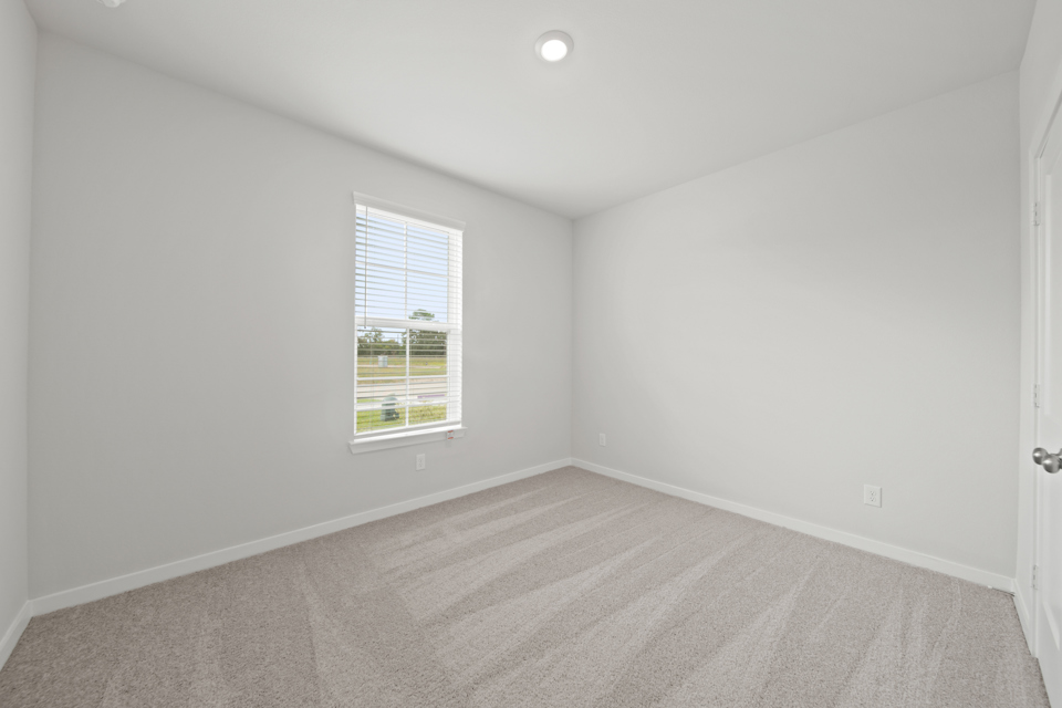 A room with a window and a carpet.