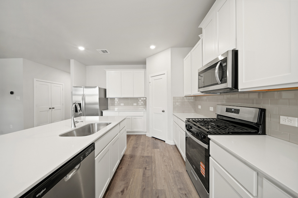 A kitchen with white cabinets.