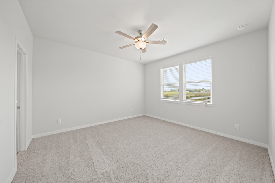 A room with a ceiling fan and a window.