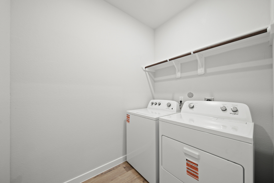 A white laundry room with a white laundry machine.