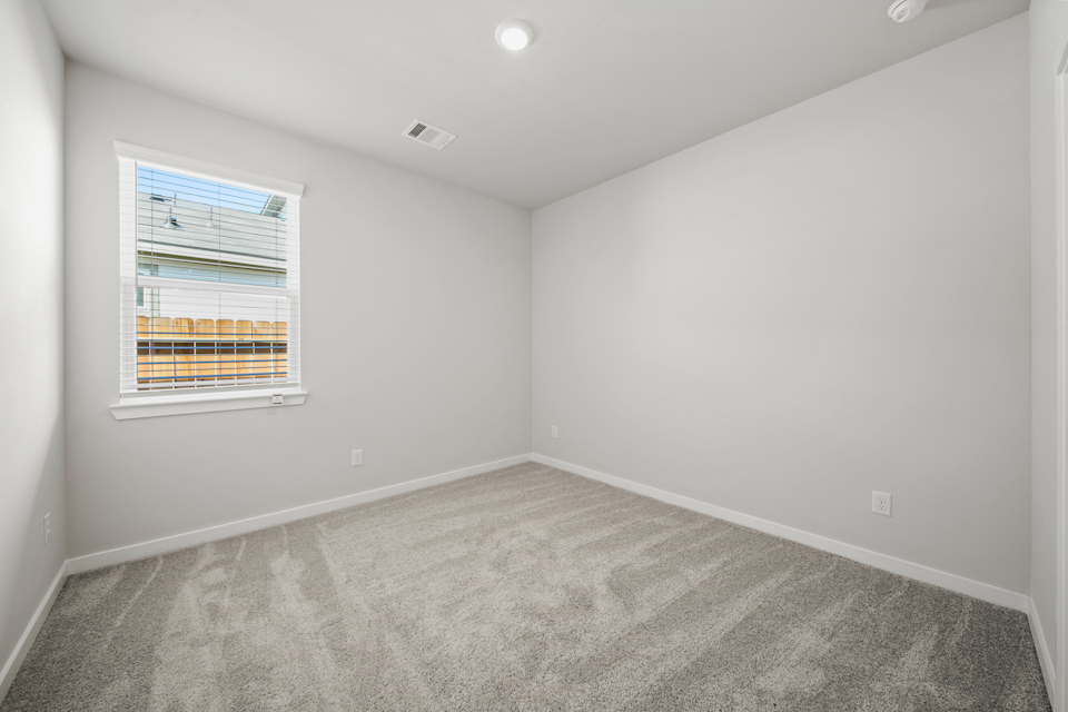 A room with a window and a carpet.