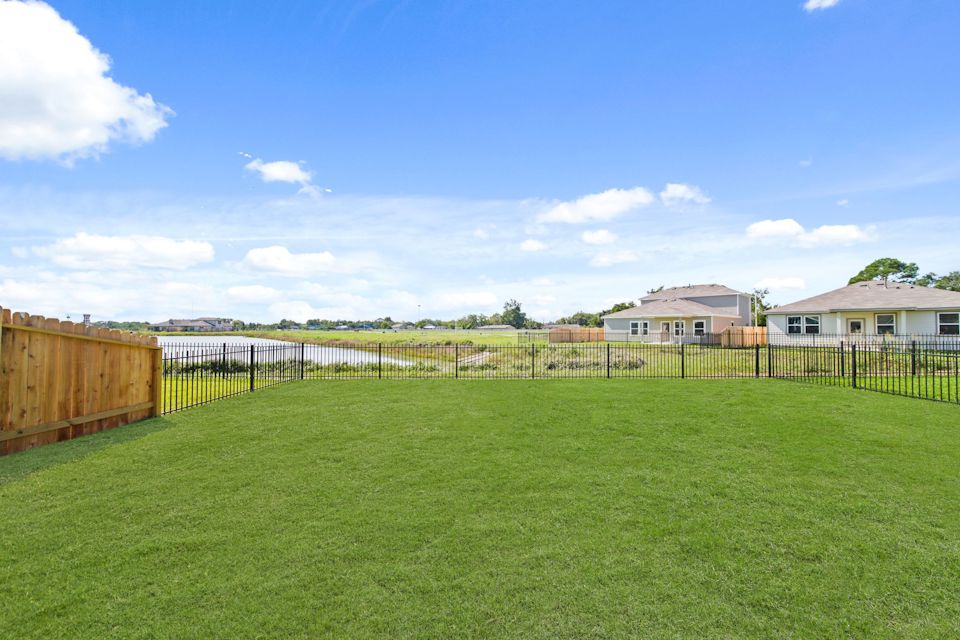 A fenced in yard with houses in the background.