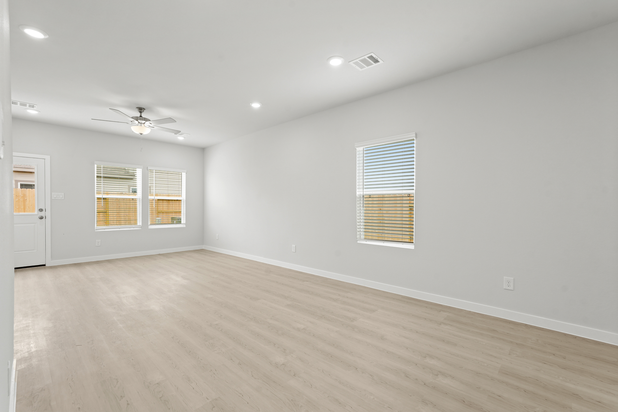 A room with a wood floor and a ceiling fan.
