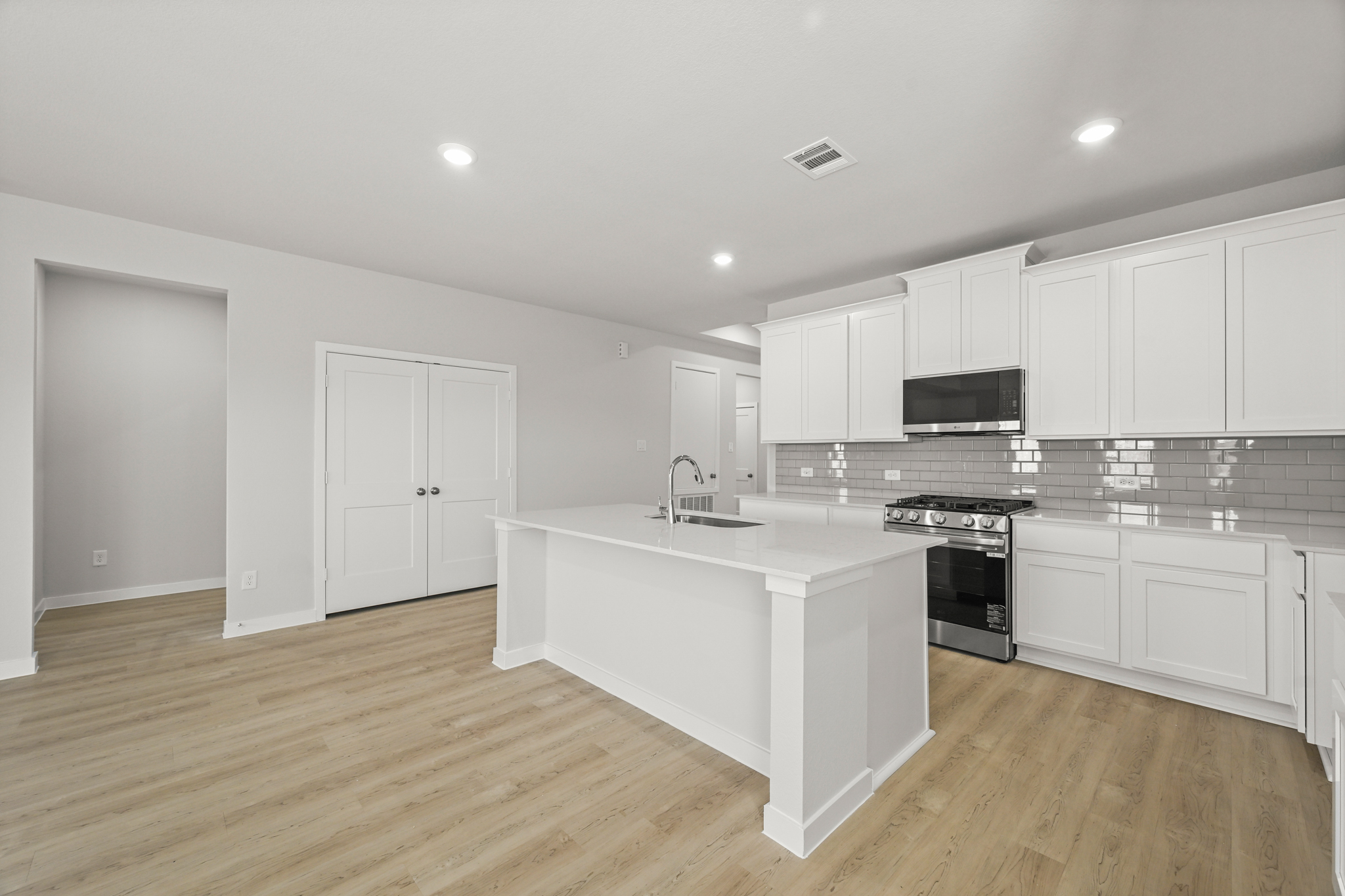 A kitchen with white cabinets.