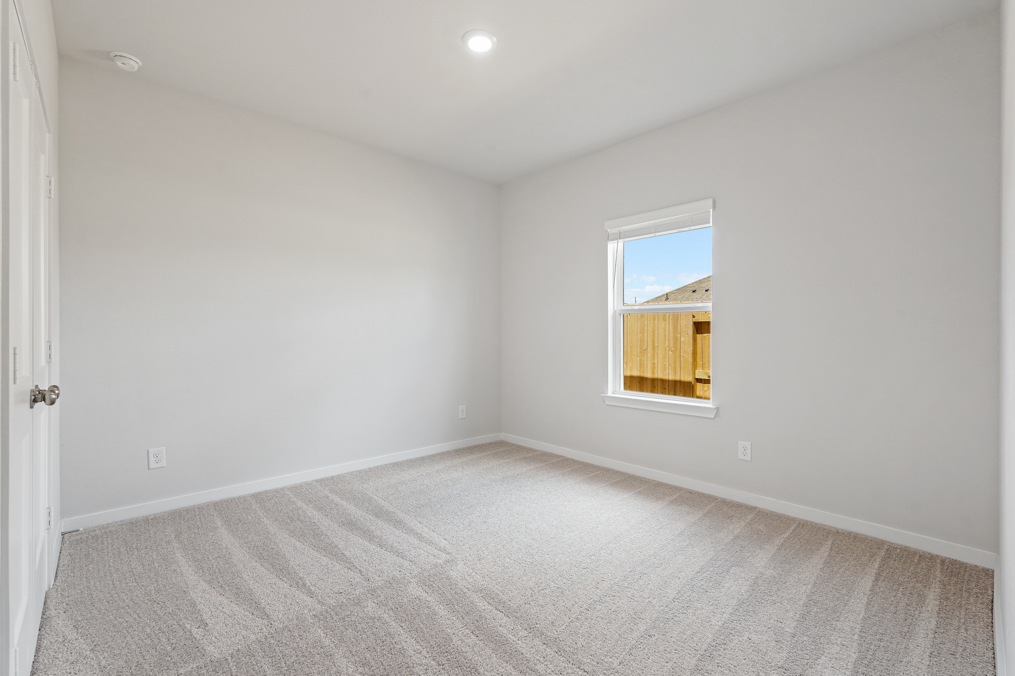A room with a window and a carpet.