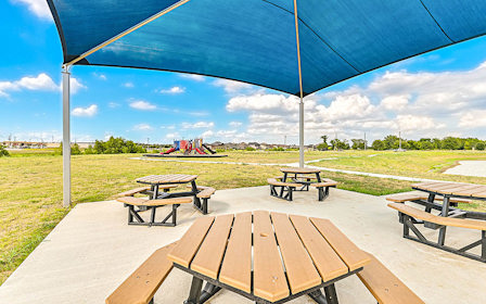 A group of picnic tables on a wood deck.
