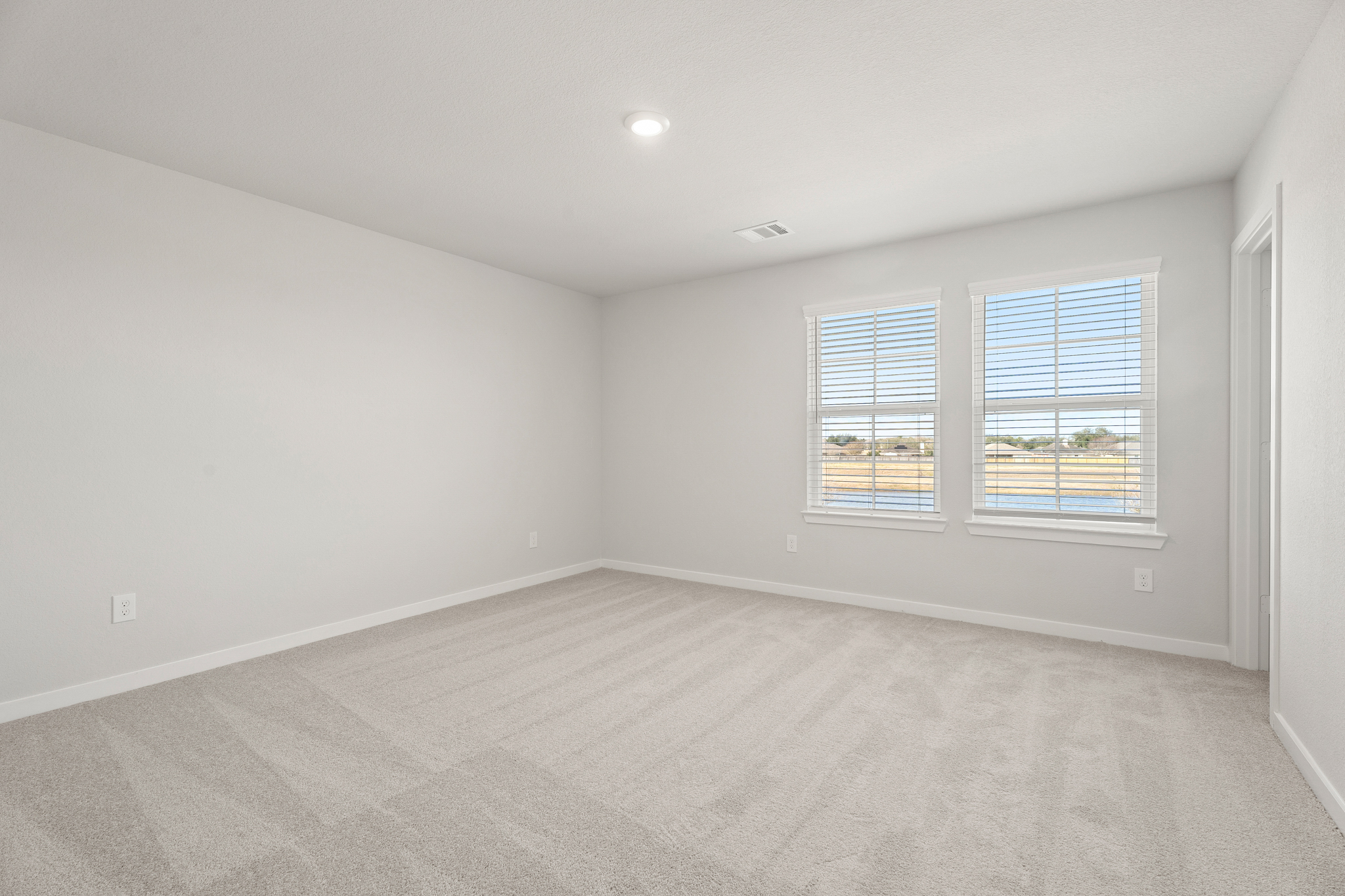 A room with a window and a carpet.