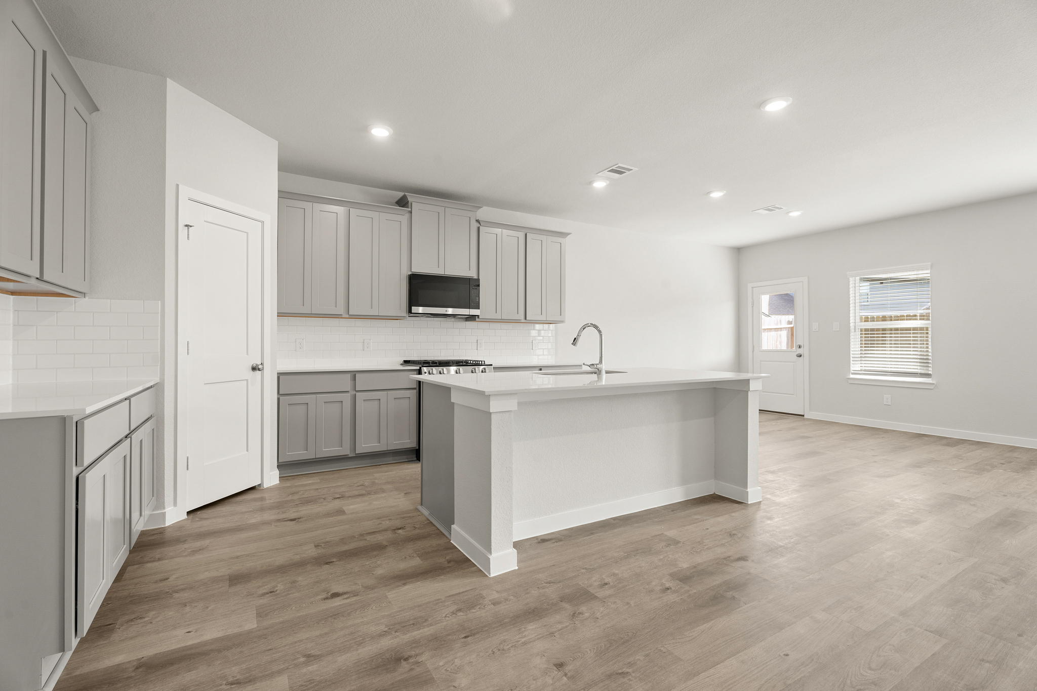 A kitchen with white cabinets.