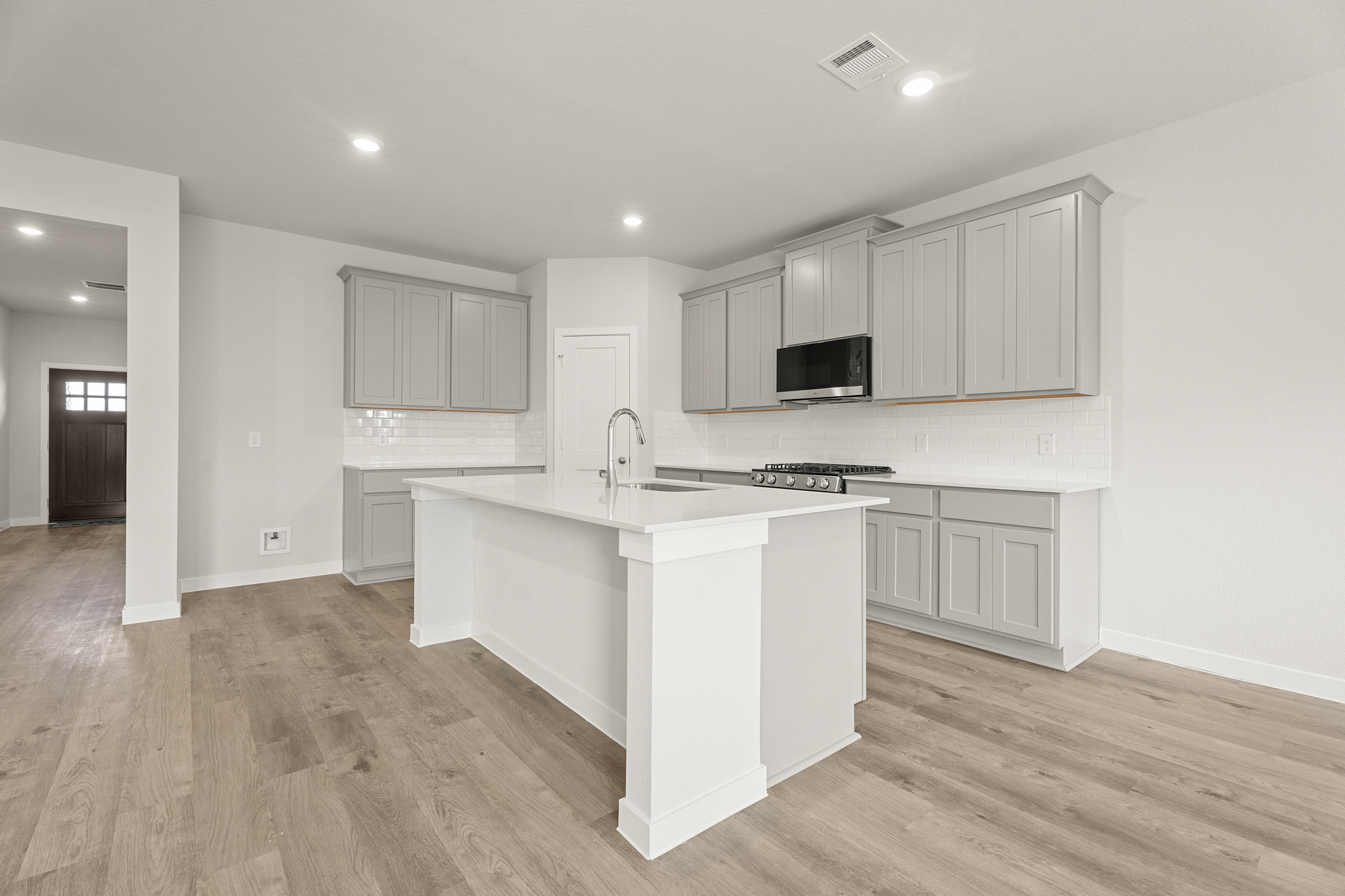 A kitchen with white cabinets.