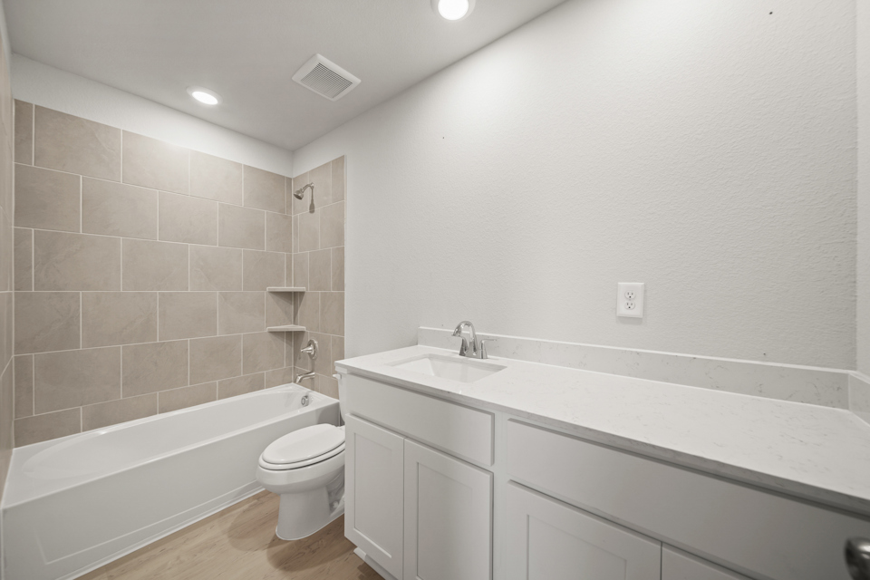 A bathroom with a tub sink and toilet.