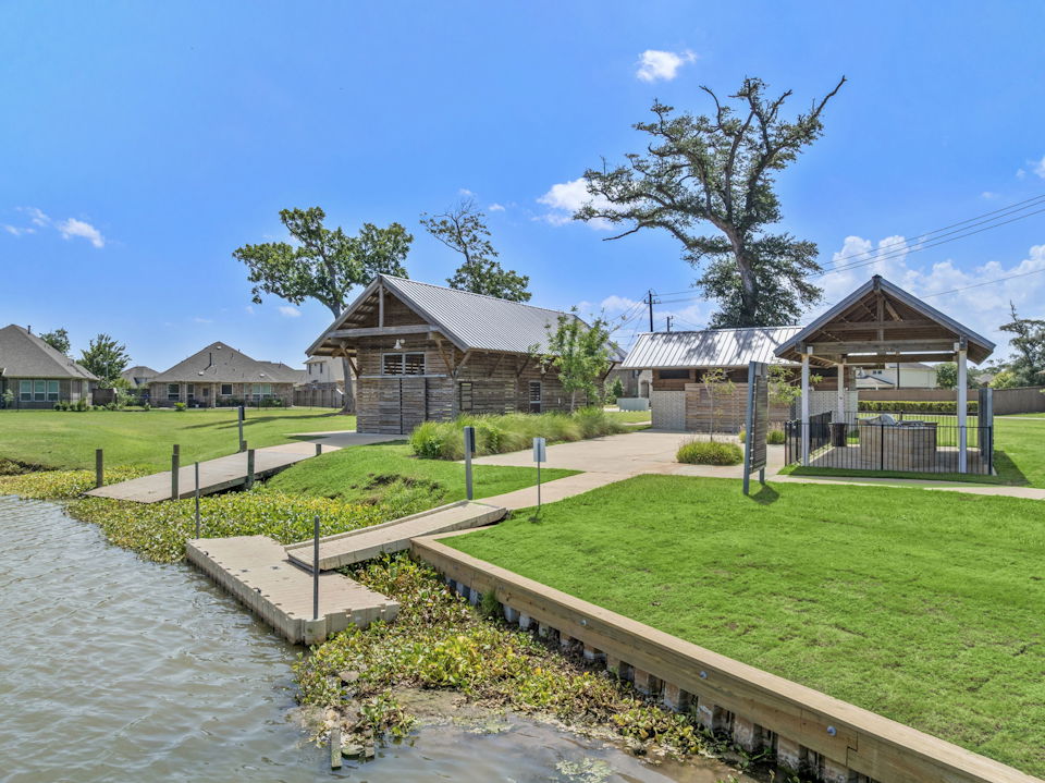 A small pond with a small building in the background.