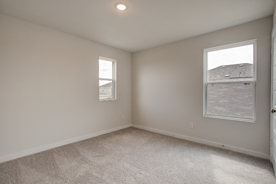 A room with a window and a carpet.