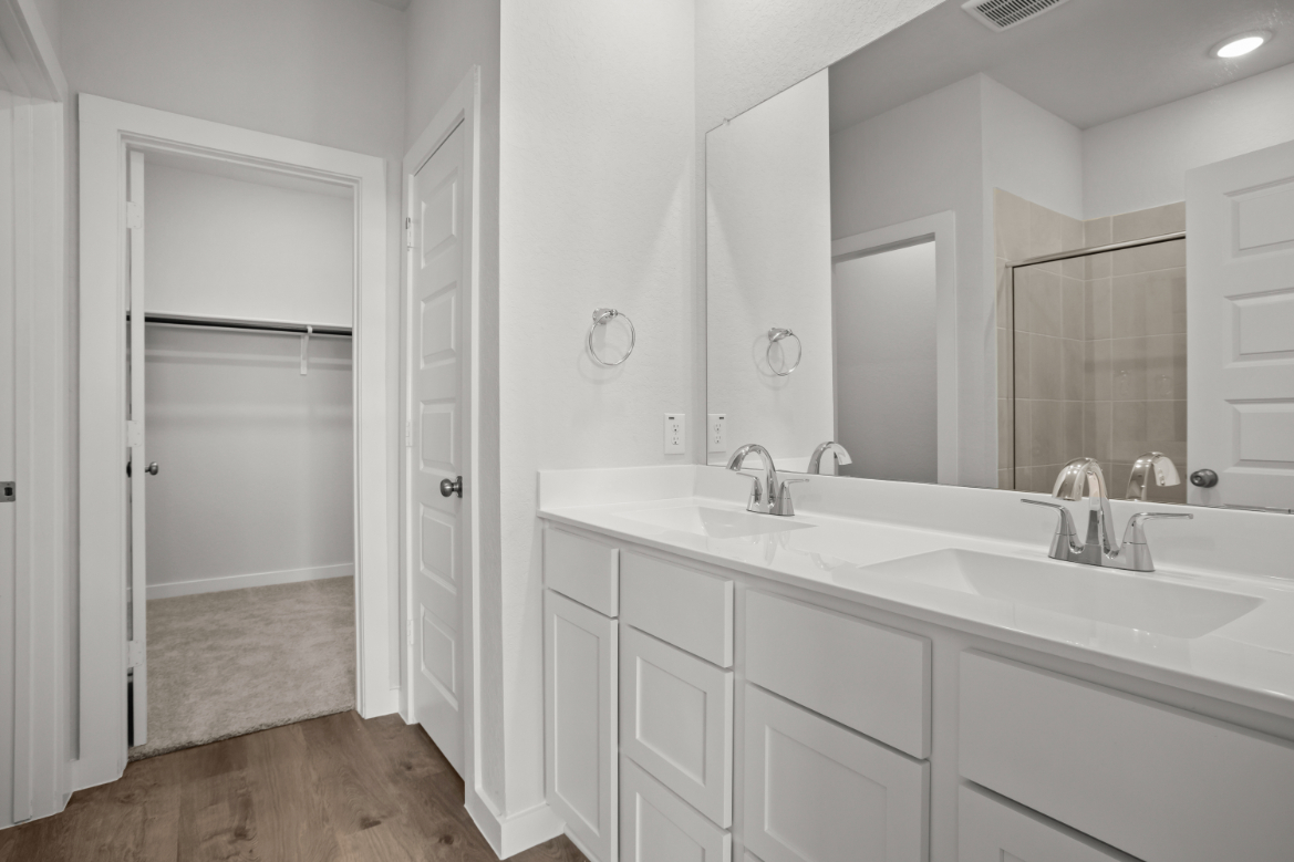 A bathroom with white cabinets.