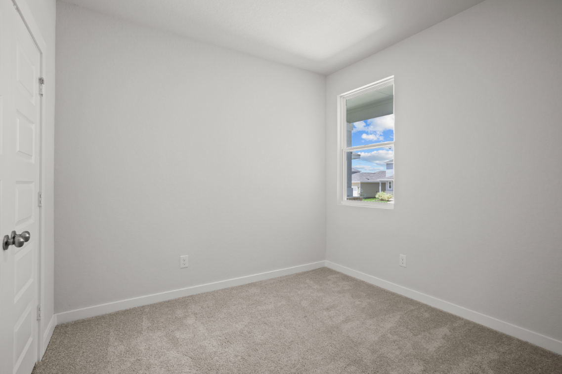 A room with a window and carpet.
