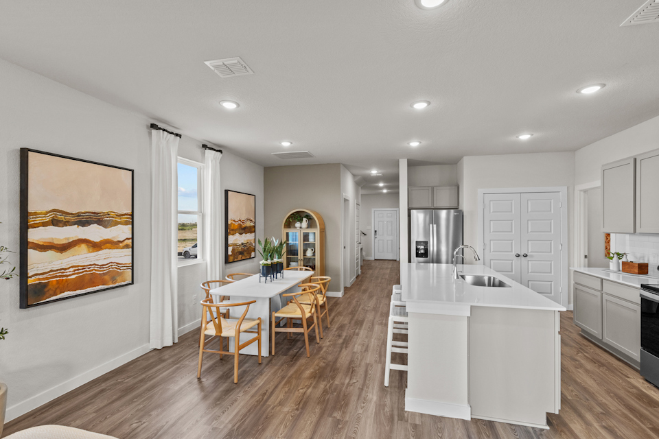 A kitchen with a dining table and a painting on the wall.