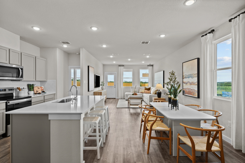 A kitchen with a dining table and chairs.