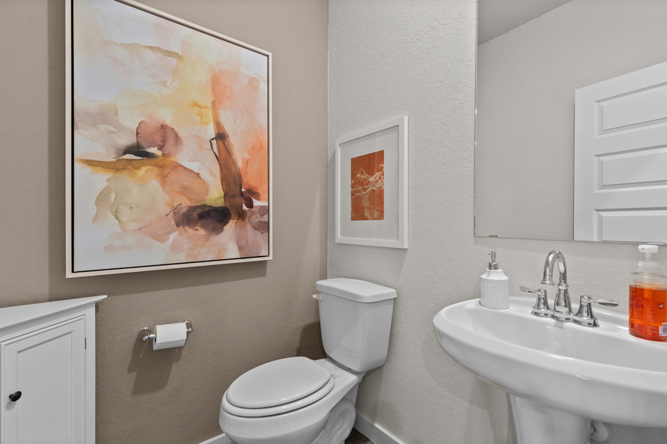 A bathroom with a painting on the wall.