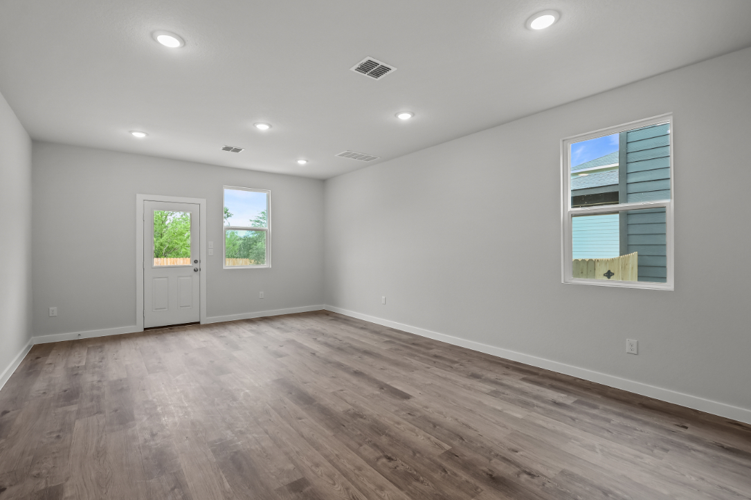 A room with a wood floor and windows.