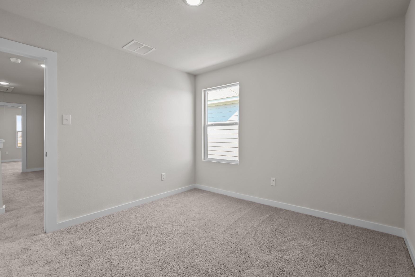 A room with a window and carpet.