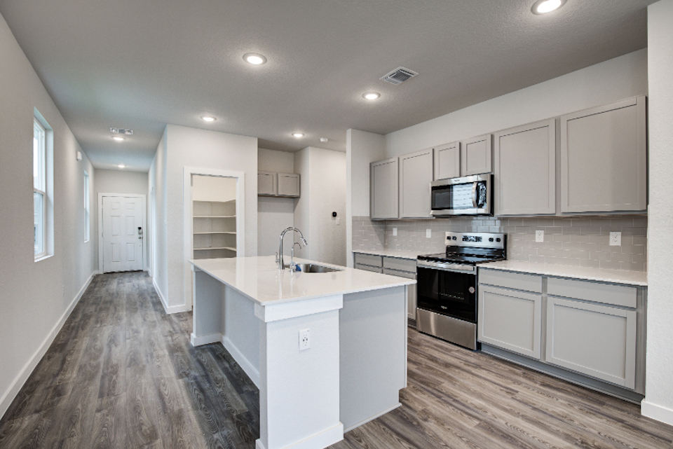 A kitchen with white cabinets.
