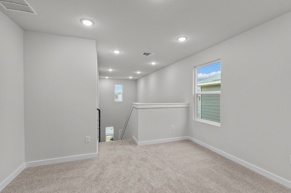 A room with a white wall and a window.