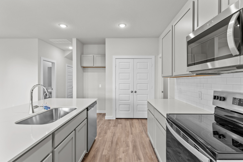 A kitchen with white cabinets.