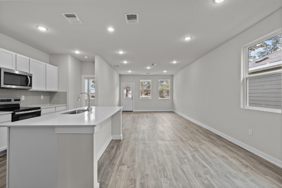 A kitchen with white cabinets.