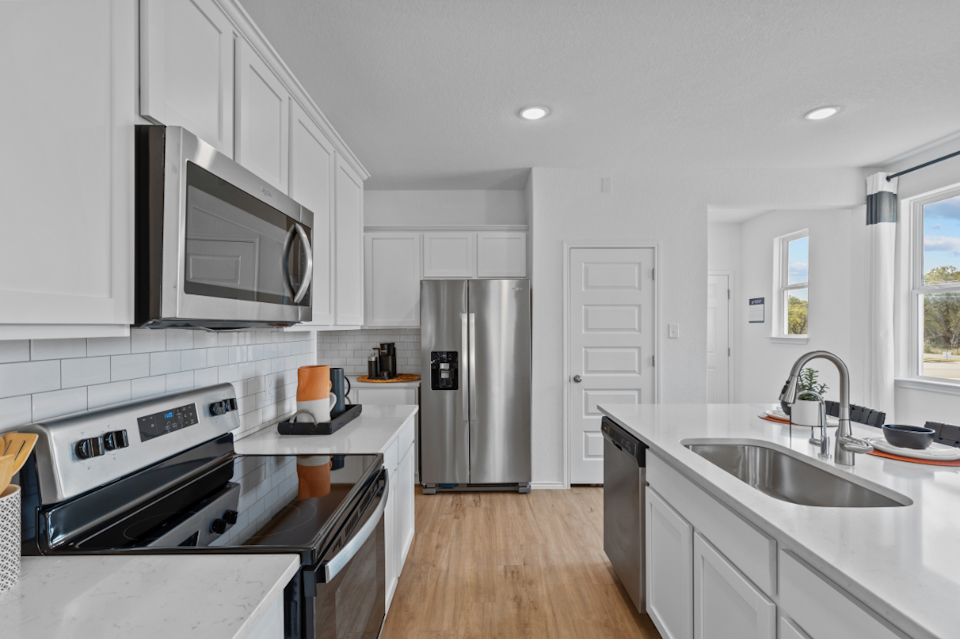 A kitchen with white cabinets.