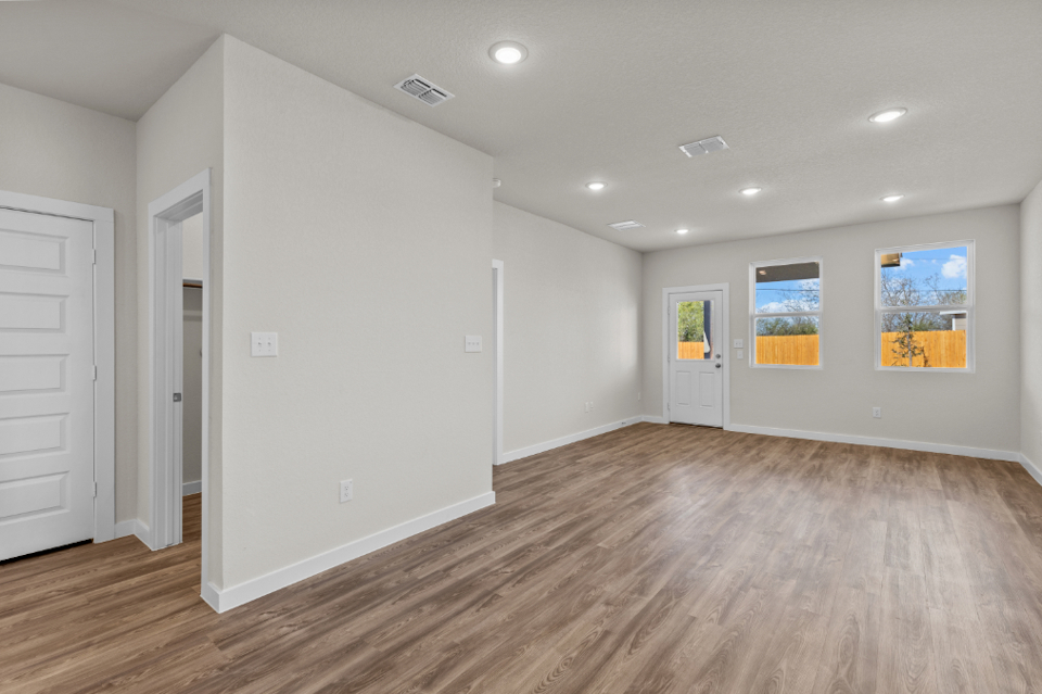 A room with white walls and wood floors.