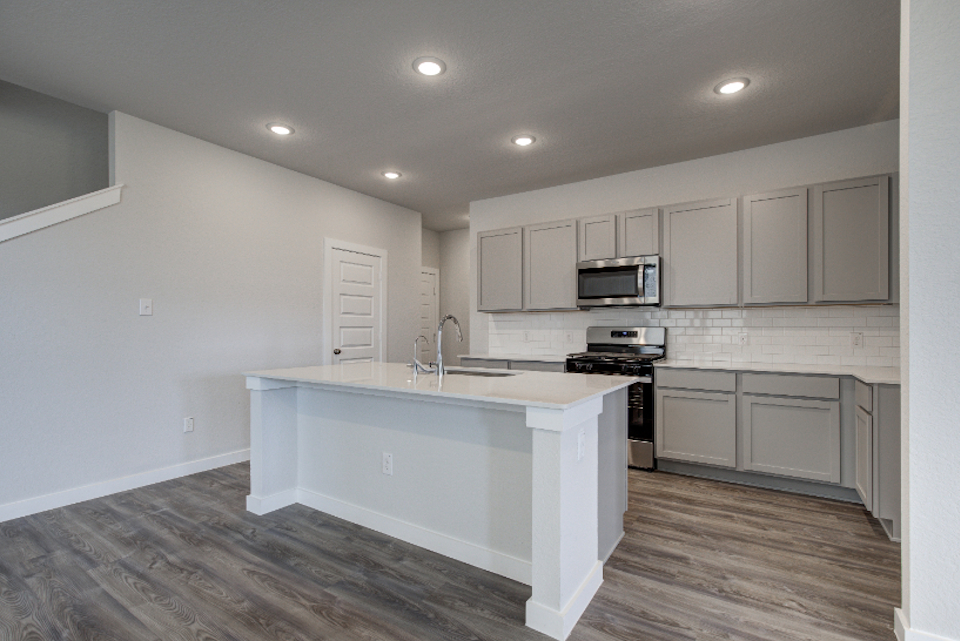 A kitchen with white cabinets.