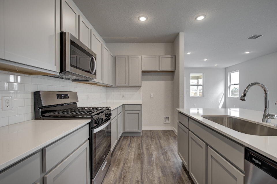 A kitchen with white cabinets.