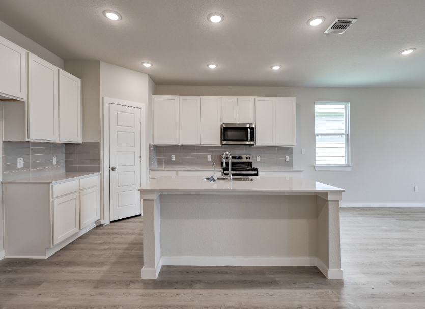 A kitchen with white cabinets.